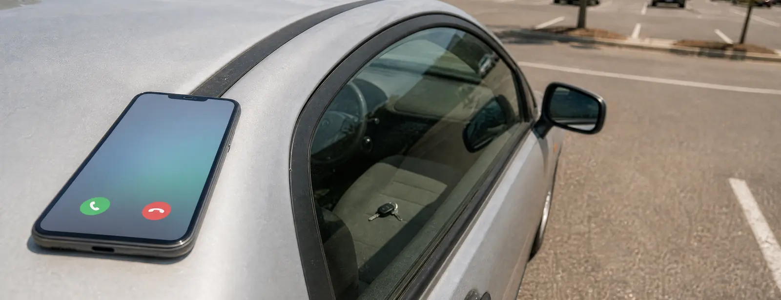 A phone ringing on the roof of a locked compact car in a sunny parking lot, with the car keys left on the driver's seat behind the closed window.